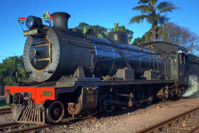 The black and orange Umgeni steam train on the railway track