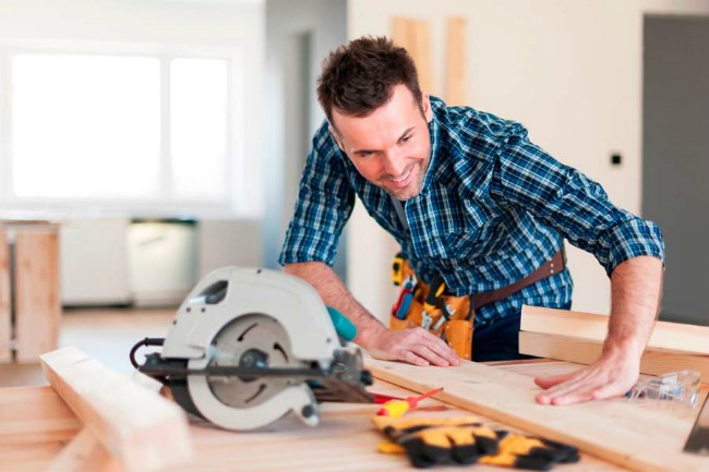 Builder working on a table with tools and wood