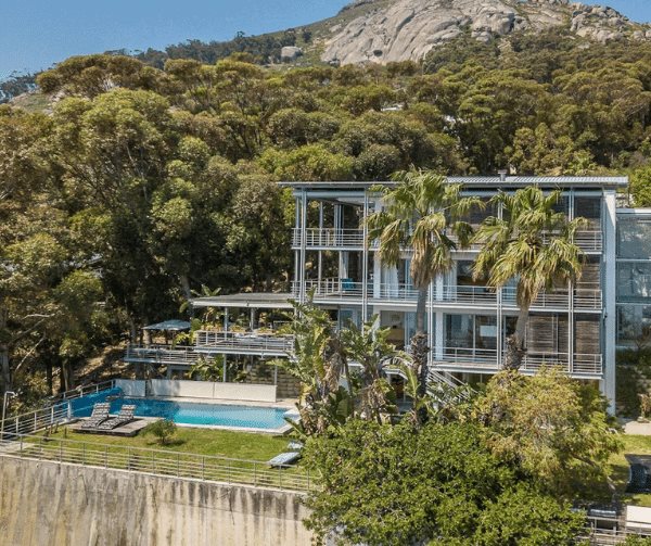 This 5 bedroom masterpiece mansion is secluded amongst a forest of blue gum trees on the slopes of the Famous Lion's Head. This stunning property has a wraparound balcony and views of the Atlantic Ocean.