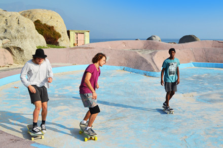 Three skate-boarders at Glen Beach in Atlantic Seaboard